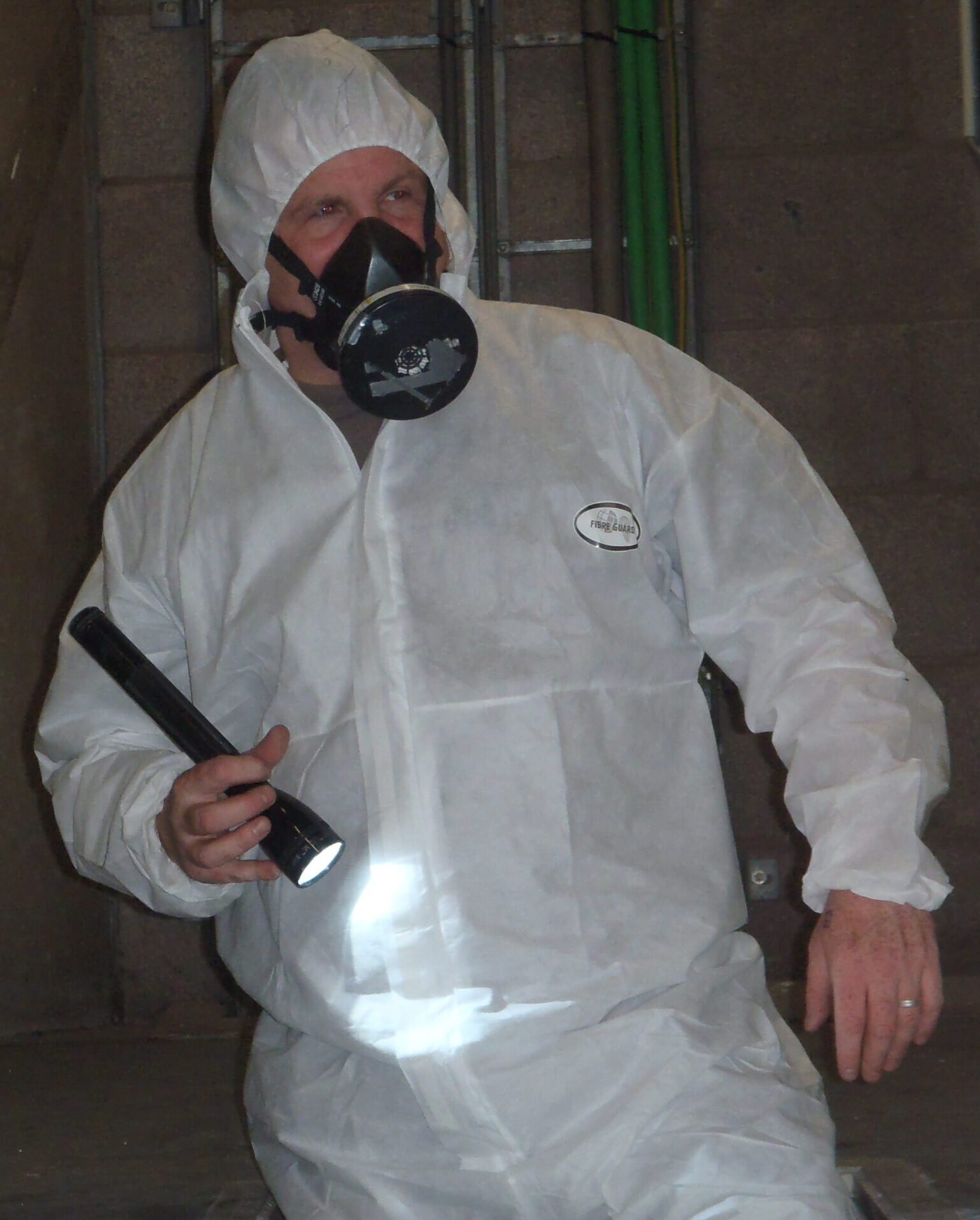 deskundig inventariseerder asbest van RPS in overall met gelaatsmasker