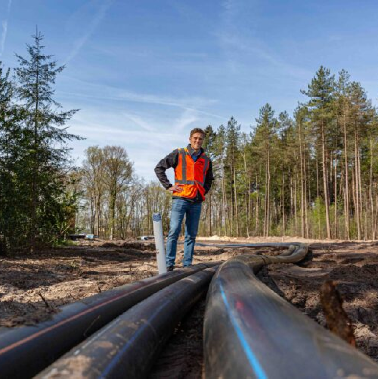 RPS-medewerker staat bij kabels als onderdeel van de ondergrondse infrastructuur in een natuurlijke omgeving